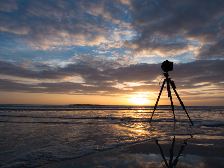 A photo taken from behind the tripod on the beach that took the prior image.